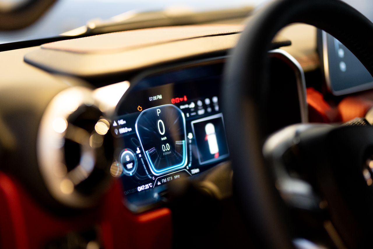 about-01 Close-up of illuminated car dashboard interior showing digital displays in Dubai showroom.